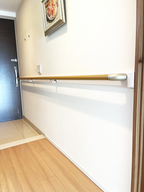 マンション玄関廊下の長い手すり白い補強板(施工例19)